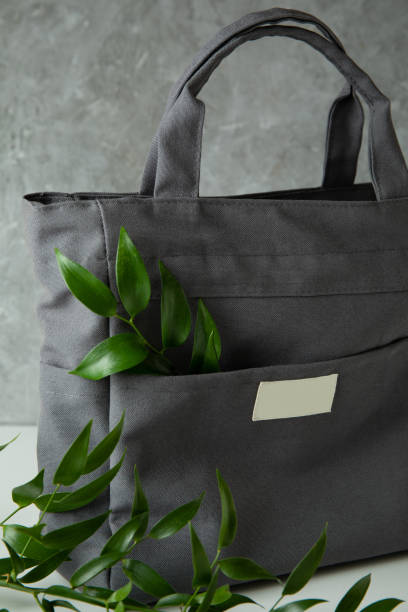 istock Stylish eco bag with branches against gray textured background 1305113713