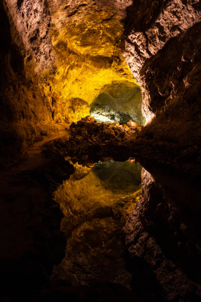istock Cave lava tube illuminated with water reflection in Canary Islands 1305114216