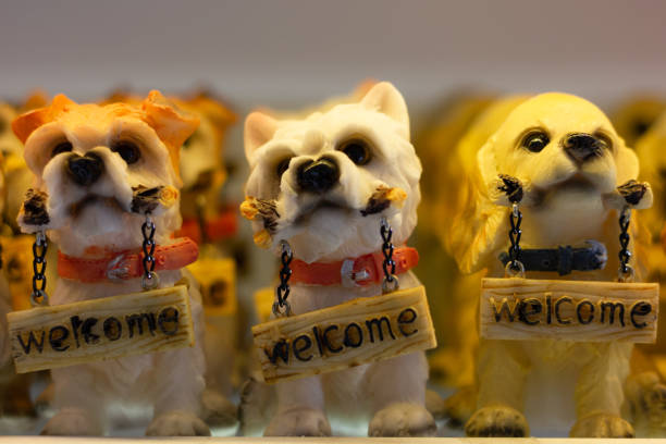 Little dogs figurines with welcome sign on. Cute puppies statues, souvenir store gift concepts