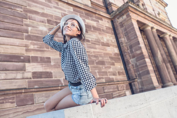 istock Trendy woman with hat and glasses posing 1305118866