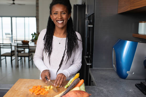 istock Woman slicing carrots at the kitchen counter. 1305122259