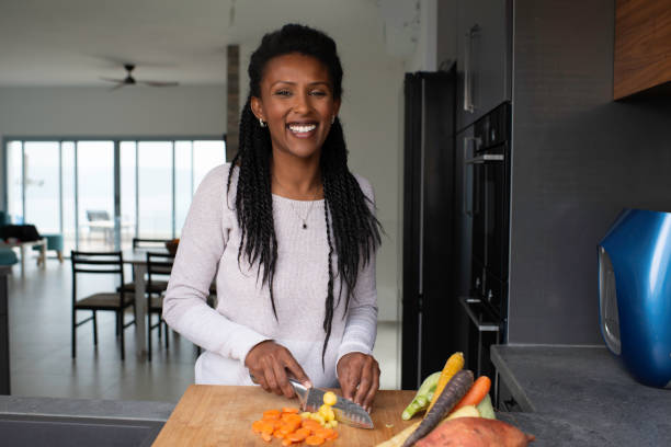 istock Woman slicing carrots at the kitchen counter. 1305122416