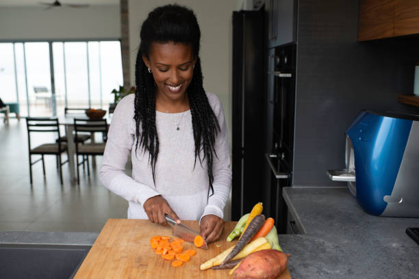 istock Woman slicing carrots at the kitchen counter. 1305122551