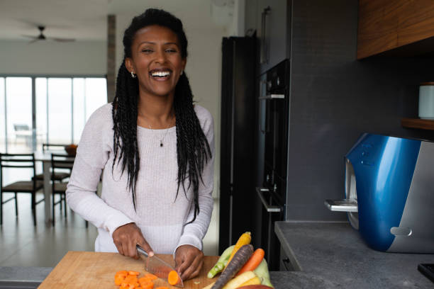Woman slicing carrots at the kitchen counter.