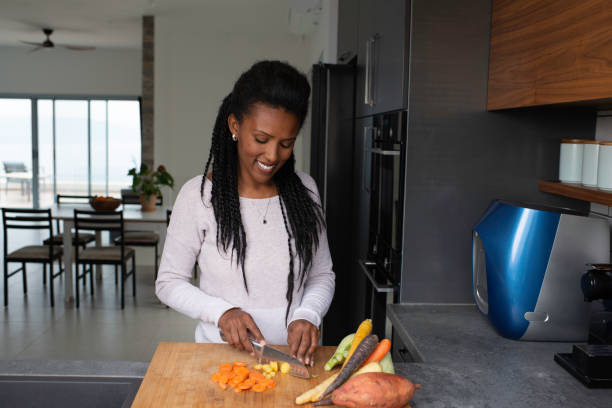 istock Woman slicing carrots at the kitchen counter. 1305122701