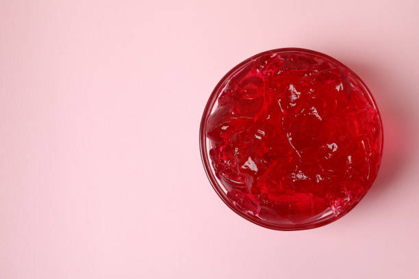 istock Bowl of red jelly on pink background 1305124773