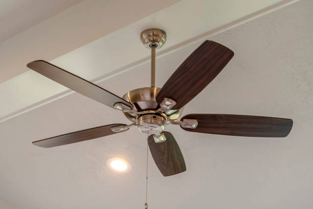 istock Electrical fan with built in lights installed on decorative wooden ceiling beam 1305125342