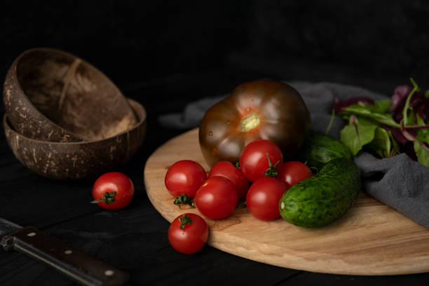 istock Ingredients for making salad on rustic black board background. Vegetable salad in bowl, tomato, cucumber, tomatoes kumato. Healthy, clean eating concept. Vegan or gluten free diet. 1305127042