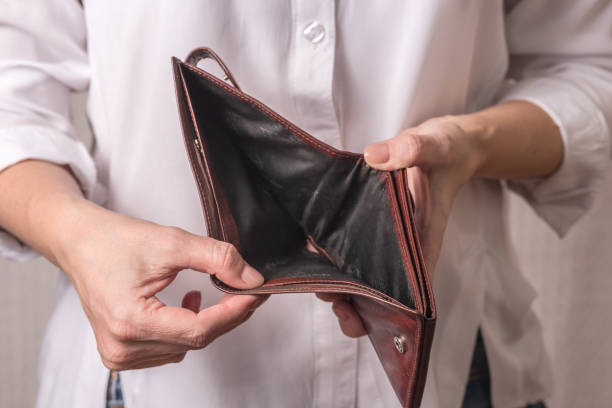 istock A woman in a white shirt is holding an empty wallet. Business problems. 1305129655