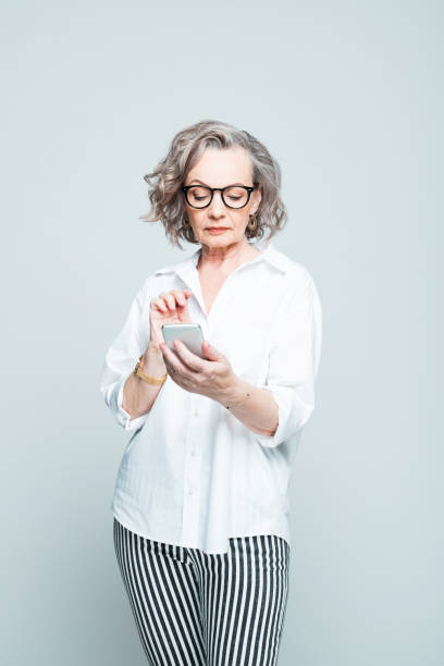 istock Confident senior woman using mobile phone 1305130679