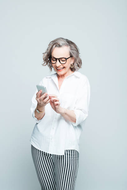 istock Excited senior woman using mobile phone 1305131076