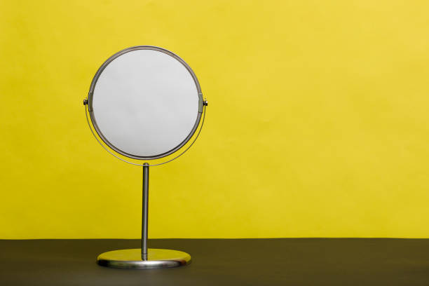 istock Round mirror on a metal stand on a yellow background with space for design. 1305135427