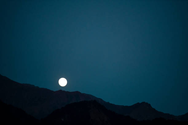 Moon rises from behind the Panchachuli range of Himalayas in  Munsyari, Pithoragarh Uttarakhand