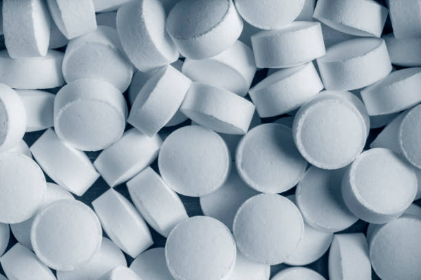 A bunch of white round pills in close-up. stock photo