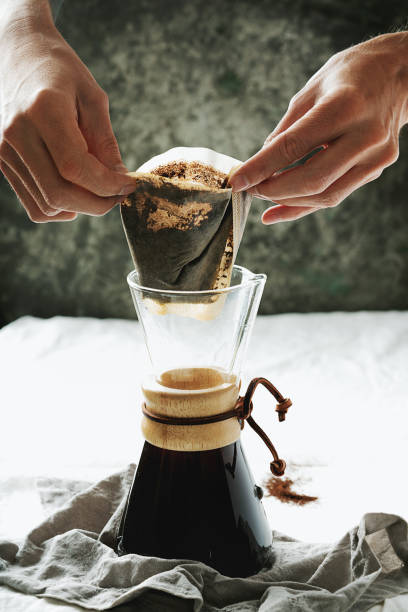 Preparing pour over,  filtered coffee with dripper, putting ground coffe in the filter. stock photo