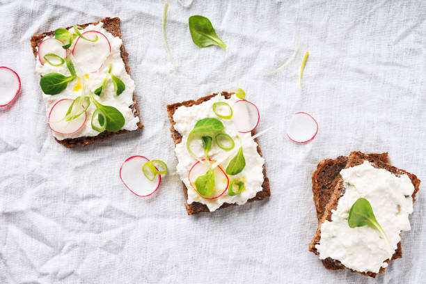 vegane sandwiches mit veganem hüttenkäse, grüner zwiebel, raddish und nativem olivenöl extra - pumpernickel stock-fotos und bilder