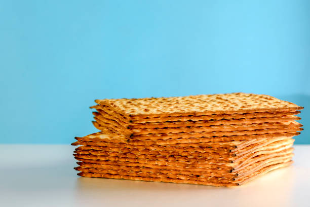 matzah sobre mesa branca sobre fundo azul. matza - tradicional páscoa judaica pão sem chumbo. símbolo de celebração de pesach - seder plate horizontal blue white - fotografias e filmes do acervo