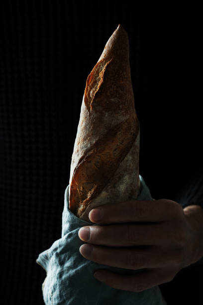 istock Traditional French bread baguette hold by man's hand 1305141049
