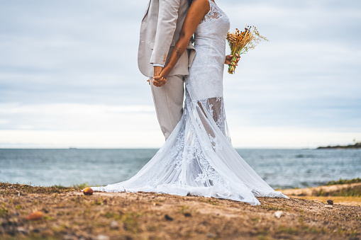 Bride and groom, Hand in hand, Wedding wear, Neck down, Beach