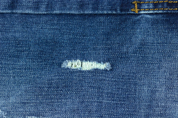 istock blue jean texture with a hole and threads showing 1305142108