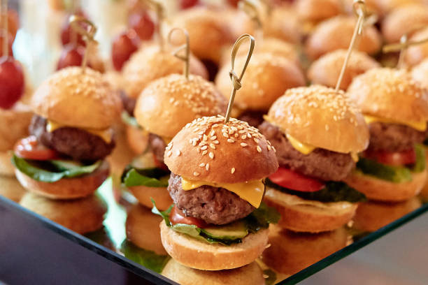 Buffet table with mini hamburgers at luxury wedding reception, copy space. Serving food and appetizers at restaurant. Catering banquet table stock photo
