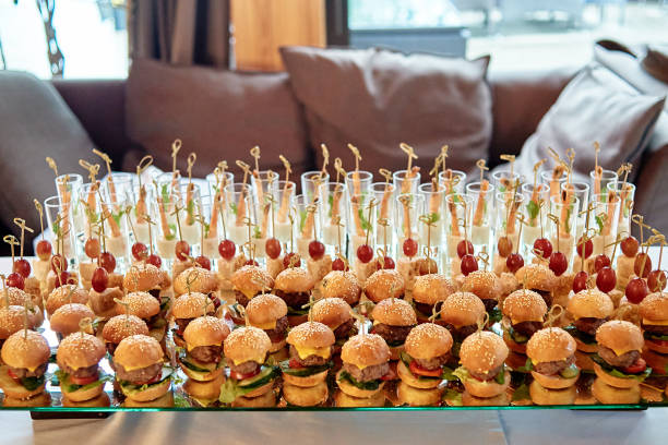 Buffet table with mini hamburgers at luxury wedding reception, copy space. Serving food and appetizers at restaurant. Catering banquet table stock photo