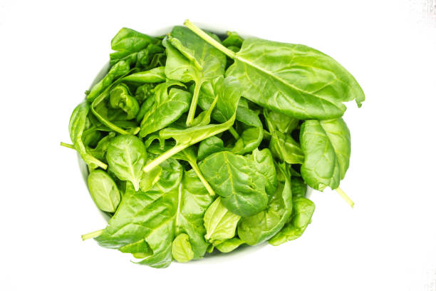 istock Young spinach in bowl isolated on white background top view 1305147733
