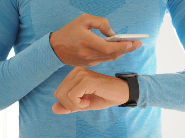 istock Man connected smartwatch with smartphone wireless. Close-up hand. 1305148625