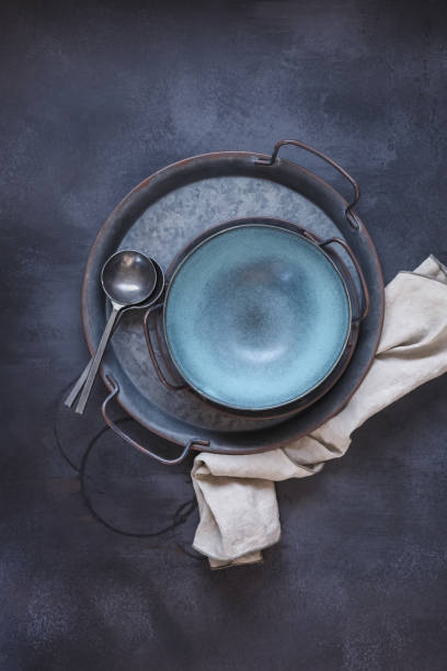 istock Empty blue ceramic bowl with vintage cutlery  on rustic metal tray 1305149036