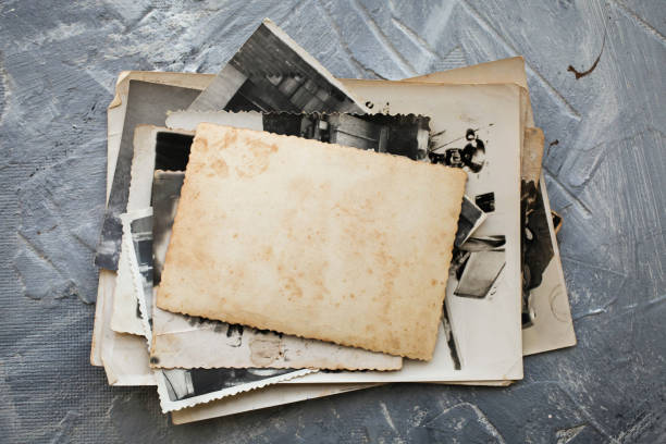 istock Stack old photos  on grey background.  Postcard rumpled and dirty vintage. Retro card 1305149202