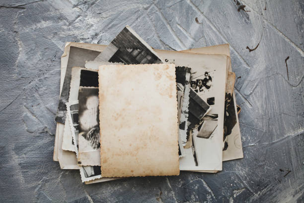 istock Stack old photos  on grey background.  Postcard rumpled and dirty vintage. Retro card 1305149220