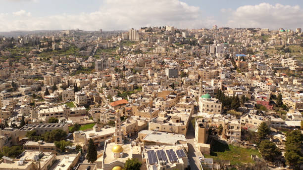 Drone view over buildings and green fields, at morning
