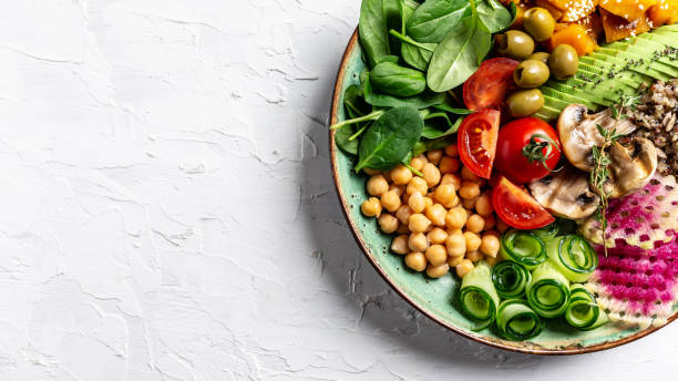 istock Buddha Bowl with Quinoa, Avocado, mushrooms, cucumber, chickpeas, spinach, tomatoes, vegetables salad. Clean eating, dieting, vegan food concept. top view 1305153439