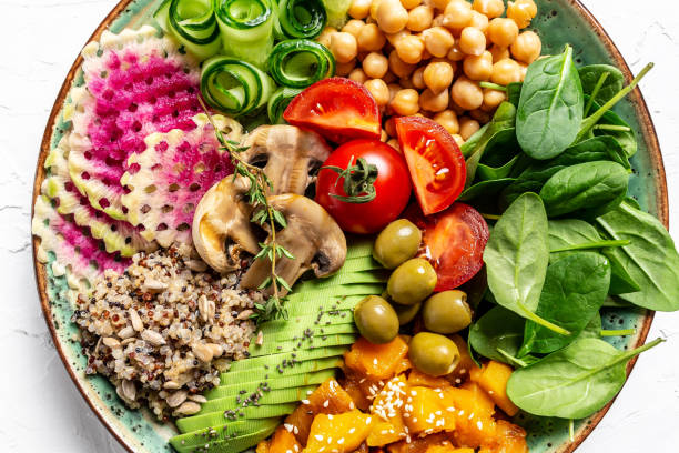 istock Buddha Bowl with Quinoa, Avocado, mushrooms, cucumber, chickpeas, spinach, tomatoes, vegetables salad. Clean eating, dieting, vegan food concept. top view 1305153463