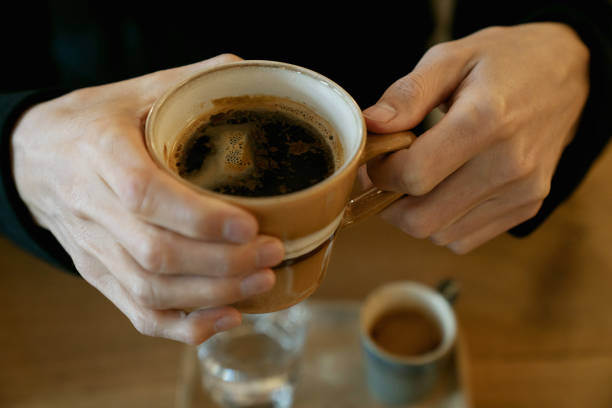 istock Middle aged man's hands holding a cup of espresso coffee 1305153558