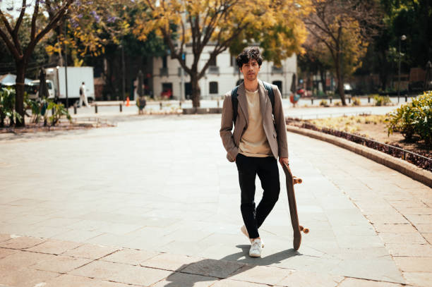 istock Young man going to work with skateboard, modern mode of transportation 1305158226