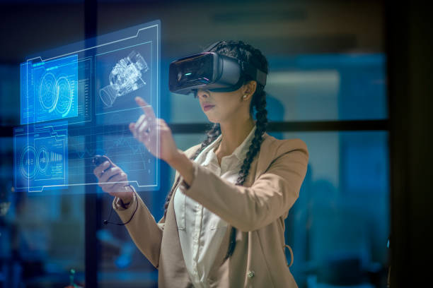 Woman wearing a VR headset at work Female engineer wearing a virtual reality headset at work to explore an upcoming mechanical engineering project. She uses her hands to manipulate and explore the finer details. hologram stock pictures, royalty-free photos & images