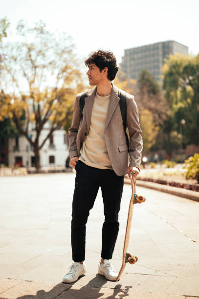 istock Portrait of man holding skateboard 1305158996