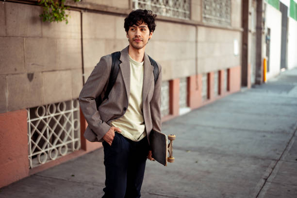 Portrait of young holding his skateboard