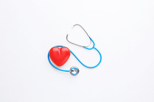 Red stethoscope and red heart shape sitting on white background. Horizontal composition with copy space. Healthcare and medicine concept.