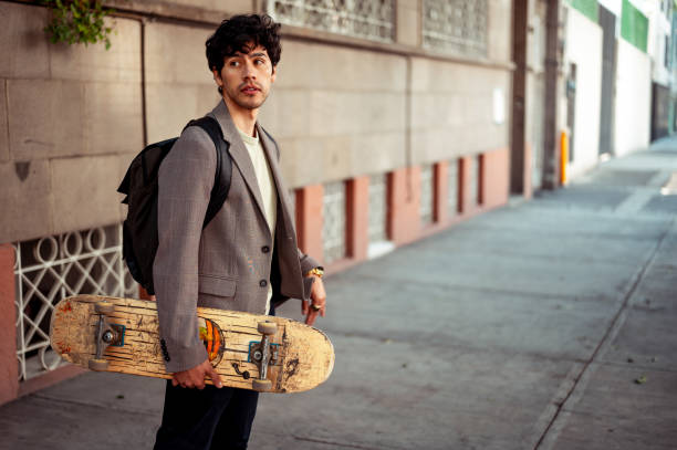 istock Portrait of young man holding skateboard 1305160929