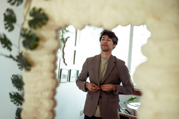 istock A reflection in the mirror of a young man getting dressed 1305161065