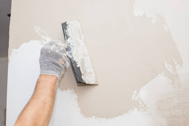 istock hand of builder worker plastering at wall.Renovation workers hand plastering the wall.Construction finishing works.work aligns with a spatula wall.process of applying layer of putty trowel 1305163083