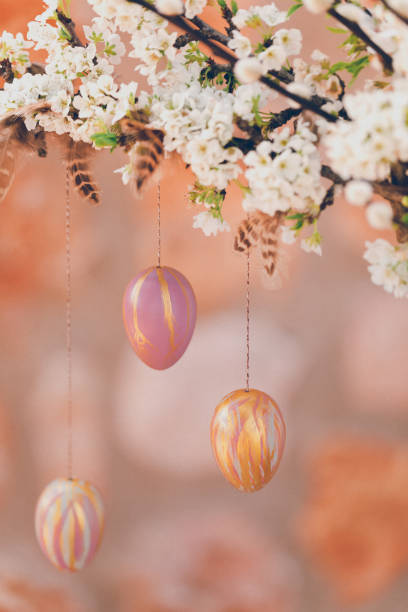 istock Still life close up with blossom branches and pussy willow decorated with self painted Easter eggs and feathers in front of a rustic stone wall 1305170601