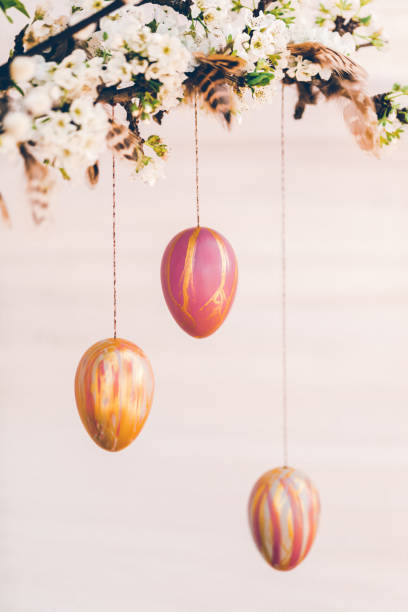 istock Beautiful blossom branches and pussy willow decorated with self painted Easter eggs and feathers on a bright rustic wooden background 1305170858