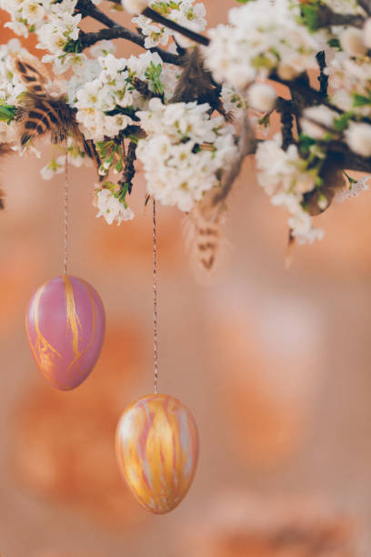 istock Still life with blossom branches and pussy willow decorated with two self painted Easter eggs and feathers in front of a rustic stone wall 1305170955