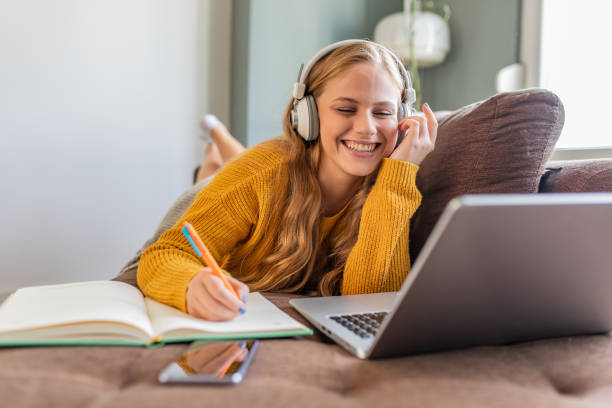 istock Beautiful young woman at home, using laptop and studying 1305172744