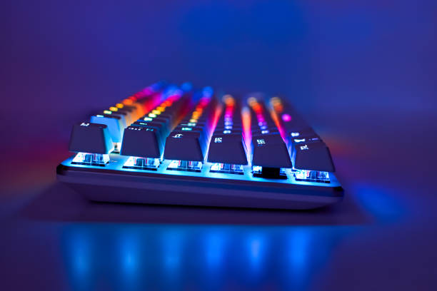 istock Backlit keyboard. Gaming keyboard with RGB light, side view. Colorful keyboard in neon light 1305173887