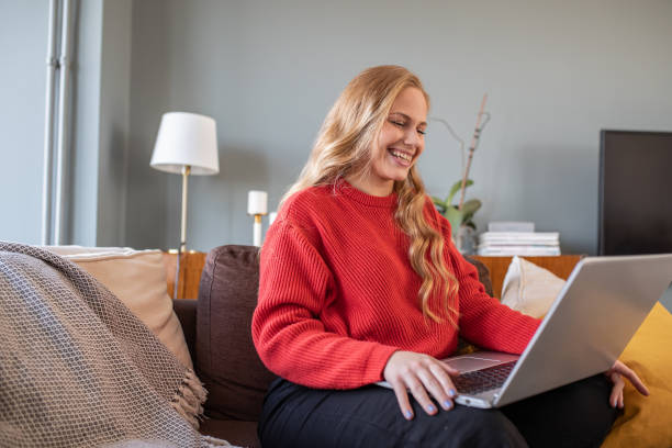 istock Beautiful young woman at home, relaxing and using laptop 1305174035
