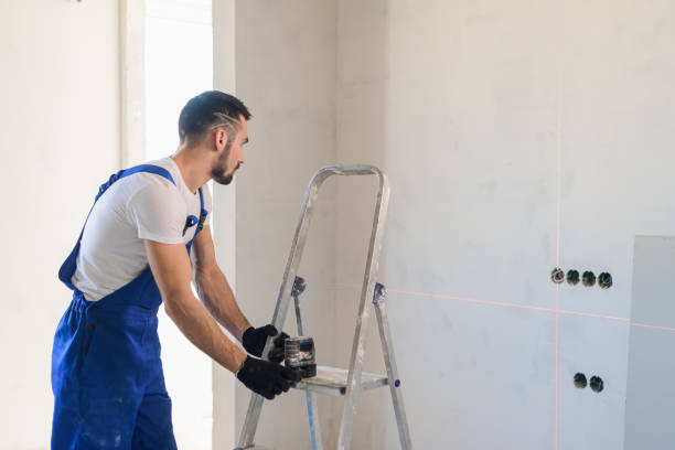 trabajador marca la pared con un nivel láser - escaleras de aluminio fotografías e imágenes de stock